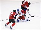 eský obránce Michal Kempný padá a kanadtí hokejisté si pihrávají na dalí...
