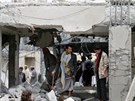 Lidé postávají u trosek po bombardování letouny ze Saúdské Arábie v jemenské...