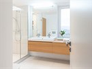 Moderní koupelna obloená velkoformátovou keramickou dlabou znaky Rako se...