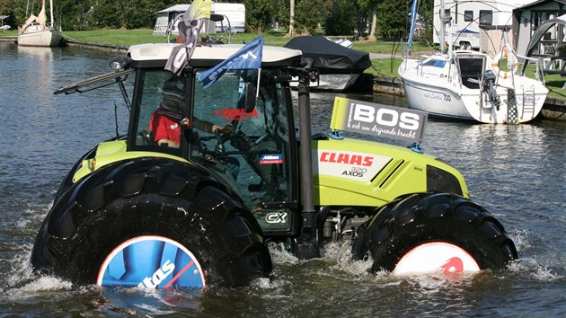 Traktor na obřích pneumatikách plul na vodní hladině.