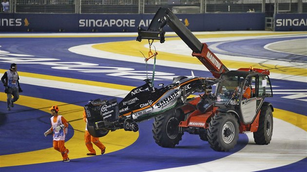 ZAPOJTE TĚŽKOU TECHNIKU. Maršálové odklízejí z trati trosky vozu, v němž během Velké ceny Singapuru formule 1 havaroval Nico Hülkenberg.