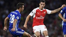 Záloník Arsenalu Granit Xhaka pihrává pes obránce Chelsea Cesara Azpiliquetu.