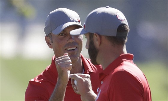 Amerití golfisté Matt Kuchar a Dustin Johnson se radují z birdie.