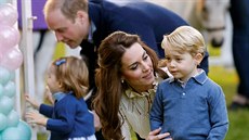 Princ George s matkou Kate a v pozadí princ William s malou princeznou...