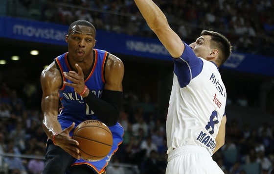 Russell Westbrook (vlevo) z Oklahoma City pihrává kolem Jonase Maiulise z...