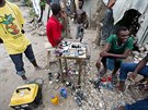 Lidé si nabíjejí své mobily pomocí generátoru. Hurikán Matthew na Haiti poniil...