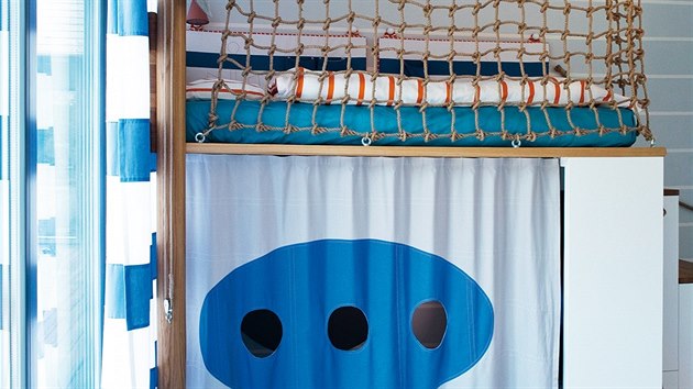 Základ pokoje tvoří zvýšená postel s námořnickou sítí. Pod ní je prostor na hraní, krytý závěsem s motivem ponorky (včetně tří okének).