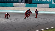Traoví komisai sbírají trosky vozu Sebastiana Vettela, který skonil hned v...