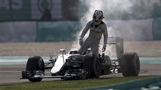 Lewis Hamilton opouští svůj hořící monopost.