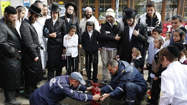 Ortodoxn chasidt id pozoruj hasie v Umani na Ukrajin pi prci. (4. jna 2016)