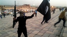 Bojovník Islámského státu v Iráku a Levant (ISIL) drí zbra a vlajku ISIL na...