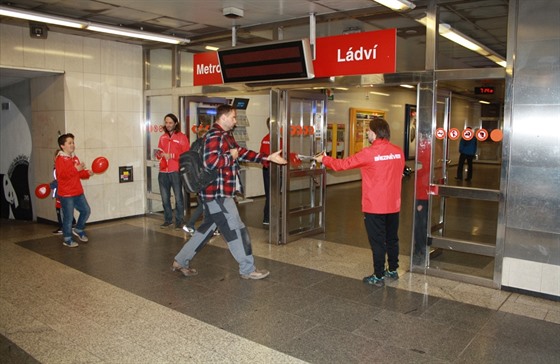 Bezinvetí fotbalisté rozdávají deník Metro ve stanici Ládví.