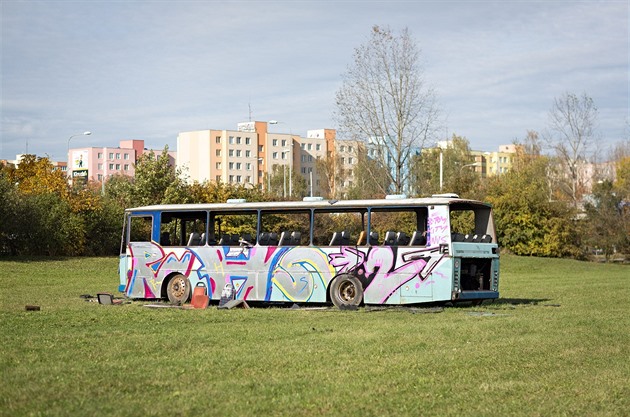 Odstavený autobus stojí mezi cyklostezkou a sídlitm Vltava, v tsné blízkosti...