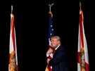 Donald Trump objímá vlajku na jednom ze svých pedvolebních mítink....