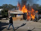 Uprchlíci zapálili na protest proti demolici tábora jednu z chat (25. íjna...