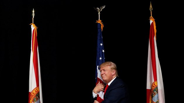 Donald Trump objímá vlajku na jednom ze svých předvolebních mítinků. (24.10.2016)