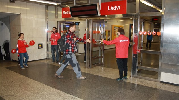 B�ezin�ve�tí fotbalisté rozdávají deník Metro ve stanici Ládví.