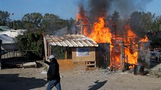 Uprchlíci zapálili na protest proti demolici tábora jednu z chat (25. íjna...