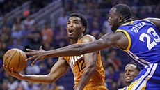 T. J. Warren (vlevo) z Phoenixu zakonuje pes Draymonda Greena z Golden State.