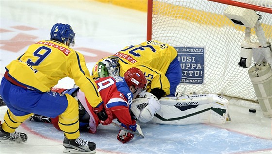 védský hokejista Niclas Andersen (vlevo) se snaí marn zabránit ve skórování...