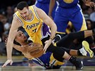 Larry Nance Jr. z LA Lakers padá na Stephena Curryho z Golden State.