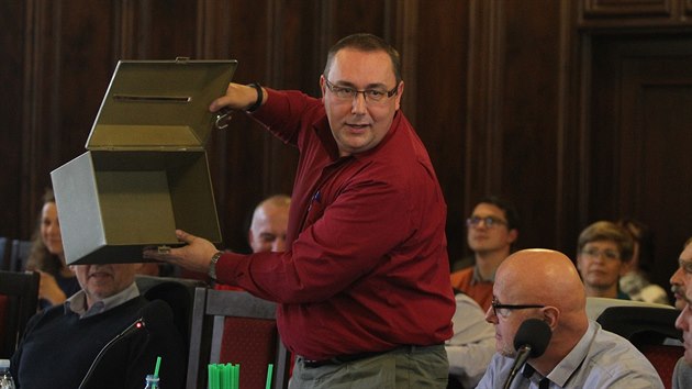 Zastupitel Roman Peschout (TOP 09) ukazuje, že urna pro tajné hlasování nemá dvojité dno.
