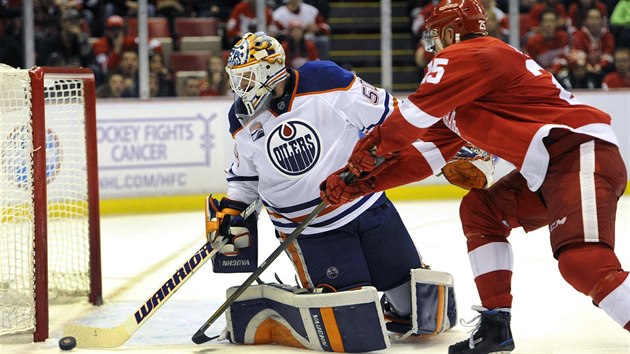 Brank Edmontonu Jonas Gustavsson vyhazuje puk ped dotrajcm  Mikem Greenem z Detroitu.