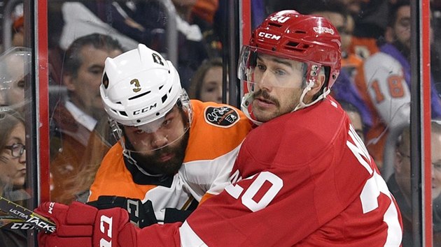 Drew Miller (vpravo) z Detroitu a Radko Gudas z Philadelphie bojuj u mantinelu.