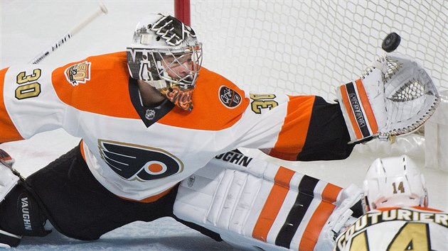 Michal Neuvirth z Philadelphie se natahuje po puku.