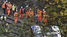 lenové záchranného sboru vyproují lidi z pevrácené tramvaje na jiním...