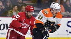 Travis Konecny (vpravo) z Philadelphie uniká Henriku Zetterbergovi z Detroitu.