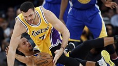 Larry Nance Jr. z LA Lakers padá na Stephena Curryho z Golden State.
