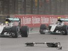 Lewis Hamilton a Nico Rosberg se vyhýbají troskám z auta Kimiho Räikkönena,...