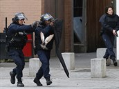 Rok poté. Na horní fotce jsou policisté na předměstí Saint-Denis na severu...