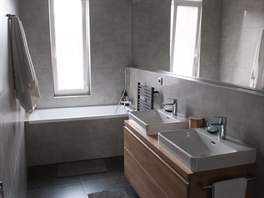 V nov� koupeln� je sprchov� kout, vana, dv� umyvadla a tak� pra�ka se su�i�kou....
