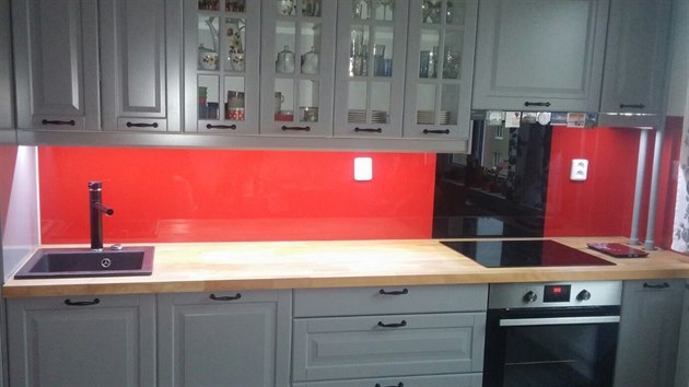 Červené sklo a podsvícení horních skříněk skvěle oživilo kuchyň s dostatečně velkou pracovní plochou i úložným prostorem.