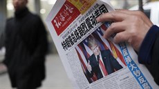 Obyvatel Pekingu studuje místní noviny s titulkem Zvolení Trumpa prezidentem...