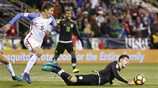 Mexický fotbalista Hector Herrera padá, Matt Besler z USA si hledí míe.