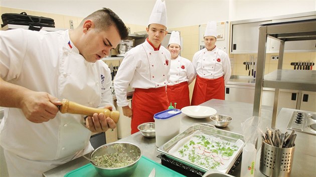 22letý kuchař Jan Horák připravuje předkrm ve školní jídelně na Bukaschool, kde ho při práci pozorují Petr, Ondra a Tomáš, žáci prvního ročníku. 