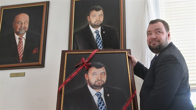 Exprimátor Opavy Martin Víteček pod svým portrétem a s fotokopií, kterou dostal na památku. Na stěně vlevo obraz Vítečkova předchůdce Zdeňka Jiráska. (21. listopadu 2016)