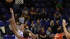 Děčínský basketbalista Lukáš Bažant (v bílém) útočí na koš Komárna.