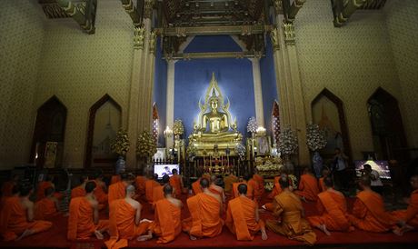 Buddhistití mnii se modlí ped portrétem zesnulého krále Pchúmipchona...