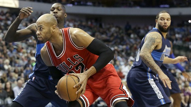 Taj Gibson (v ervenm) z Chicaga se tla do Doriana Finneyho-Smithe, sleduje je Deron Williams.