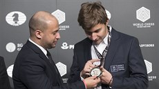 Sergej Karjakin (vpravo) si prohlíí medaili útchy pro poraeného v boji o...