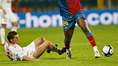 Le�ící Tomá� Jirsák v dresu Wisly Krakov zastavuje Yayu Tourého z FC Barcelona.