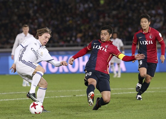 Luka Modrič z Realu Madrid kouzlí s míčem, ve skluzu je Mitsuo Ogasawara z týmu...