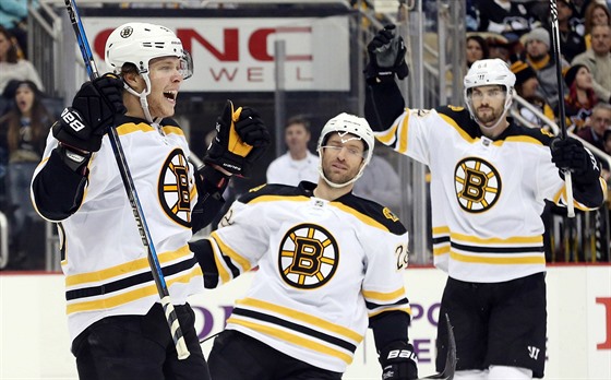 David Pastrák, Dominic Moore a Adam McQuaid (zleva) se radují z gólu Bostonu.