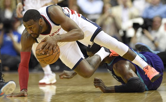 John Wall z Washingtonu padá po souboji s Royem Hibbertem z Charlotte.