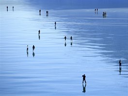 ERNÝ LED. Lidé bruslí na zamrzlé vodní nádri Lago Bianco ve výcarsku. Temné...