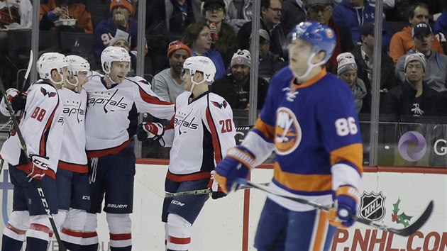 Hokejisté Washingtonu slaví gól na ledě  NY Islanders. Zklamaně odjíždí Nikolaj Kulemin.